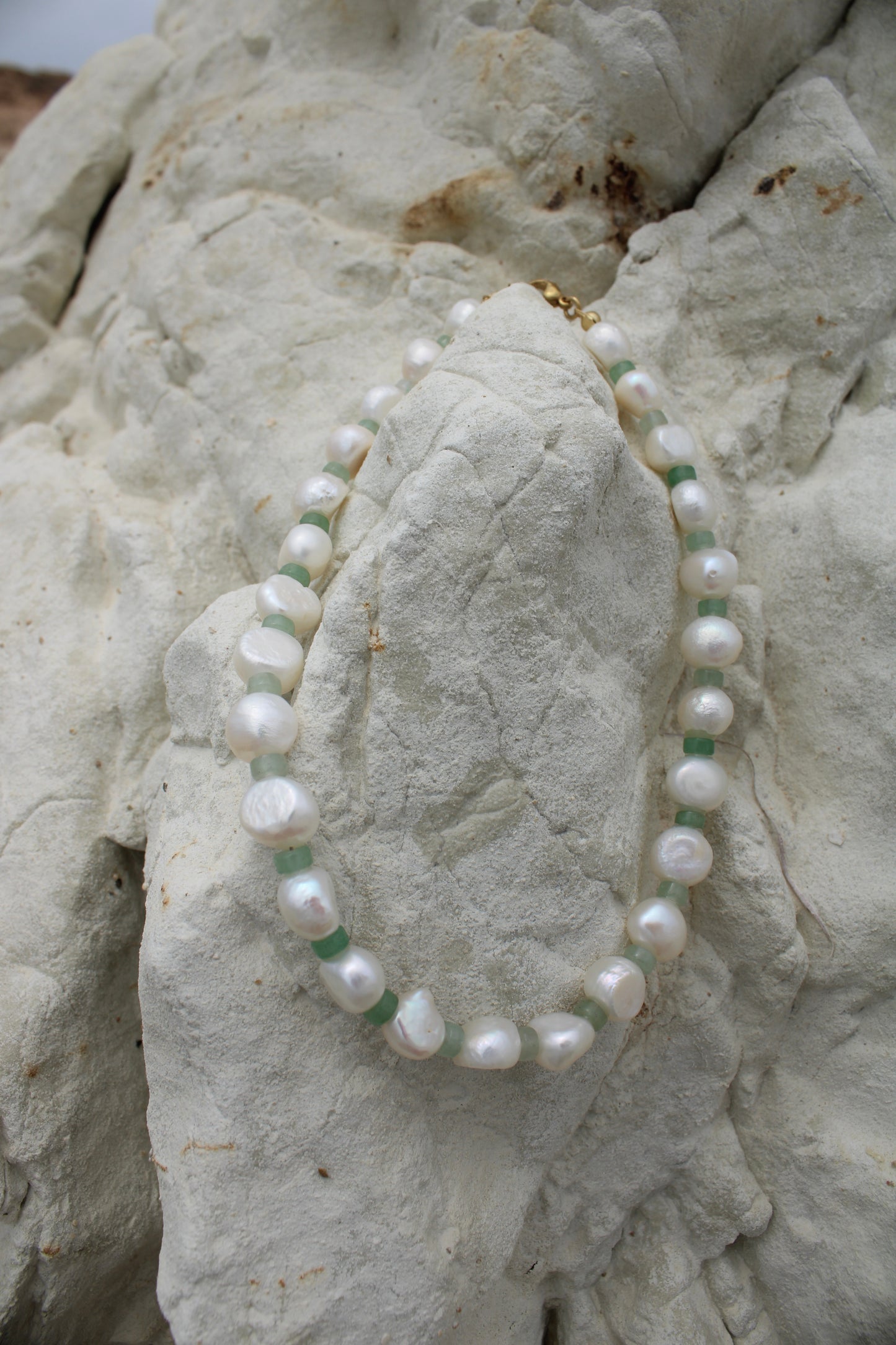Elegant white freshwater pearl necklace featuring a motif design adorned with small green beads, adding a touch of sophistication to any ensemble.