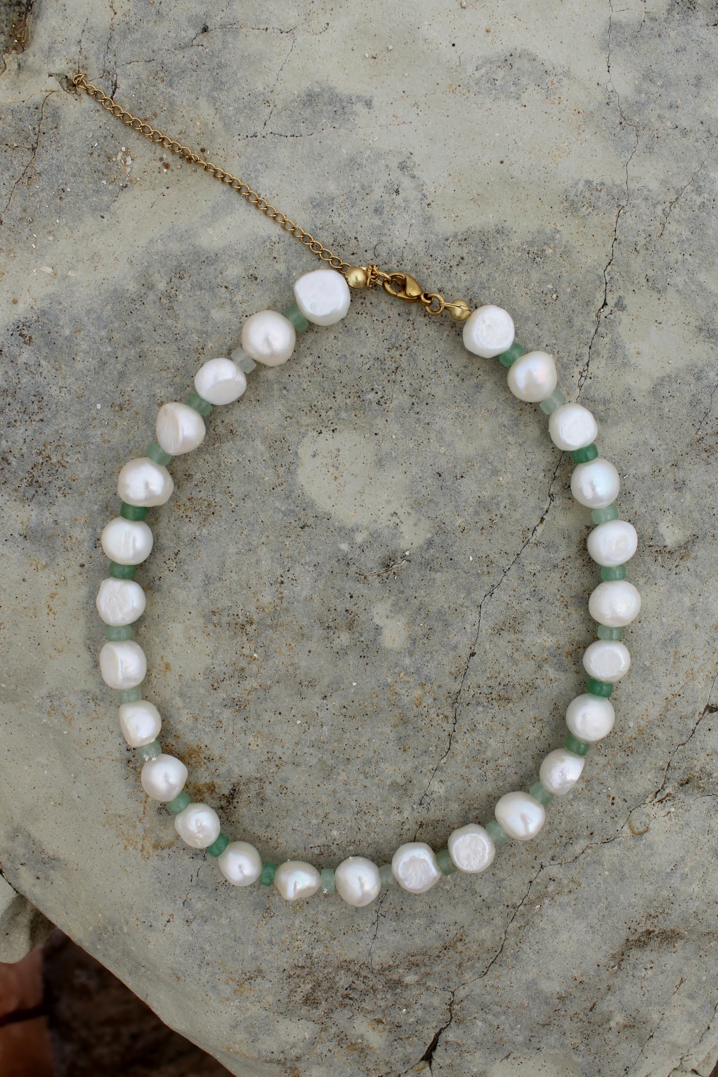 Elegant white freshwater pearl necklace featuring a motif design adorned with small green beads, adding a touch of sophistication to any ensemble.