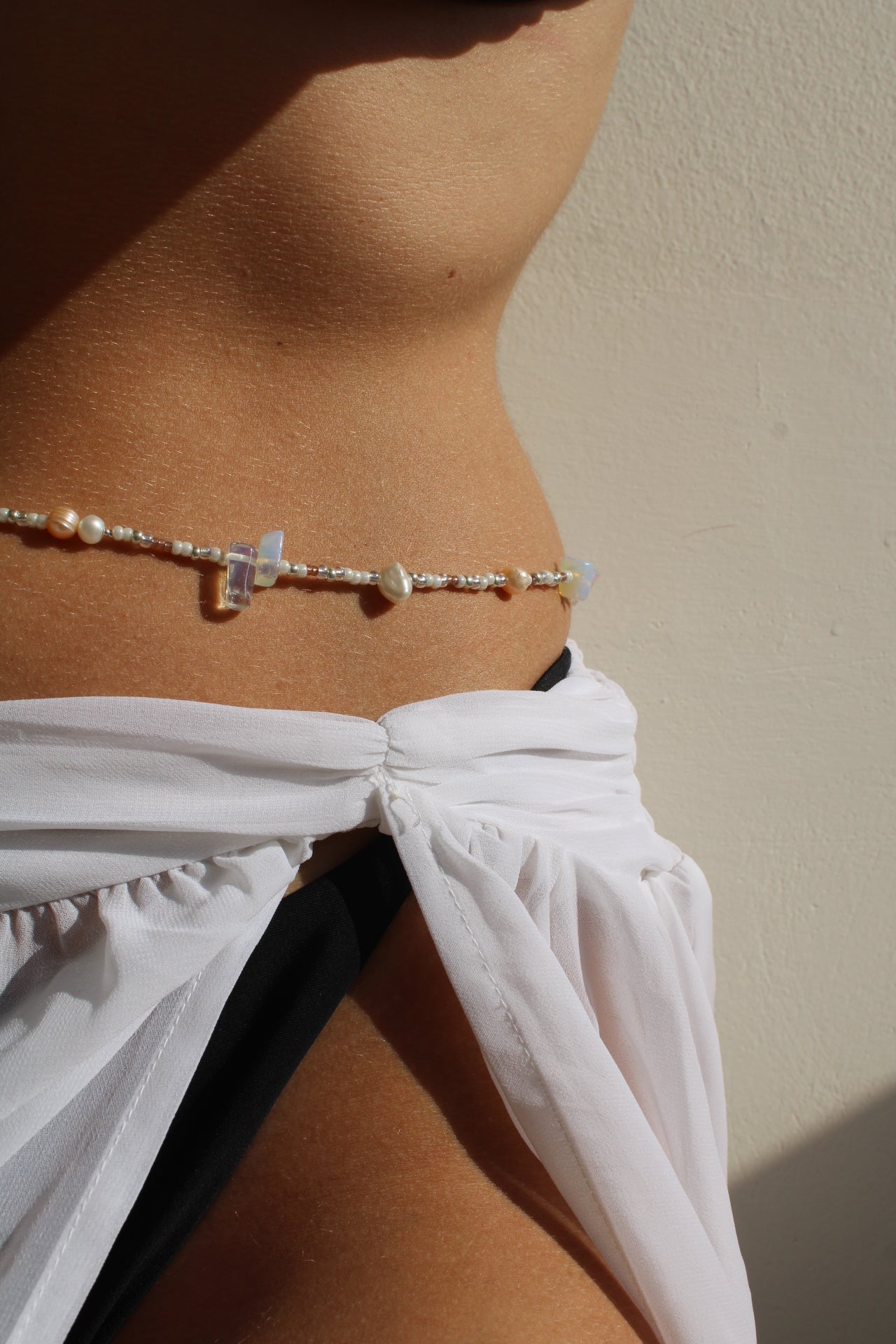 Belly chain featuring freshwater pearls and beads on a luxurious golden chain, adding a touch of elegance to your ensemble.