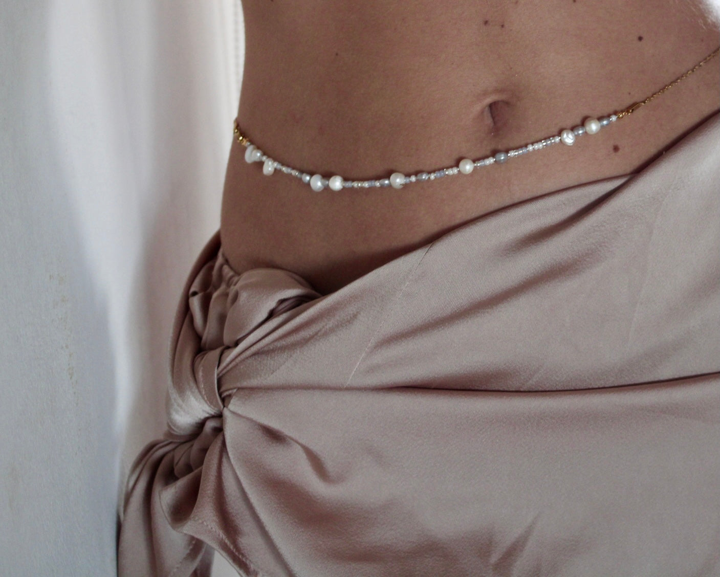 Belly chain featuring freshwater pearls and beads on a luxurious golden chain, adding a touch of elegance to your ensemble.