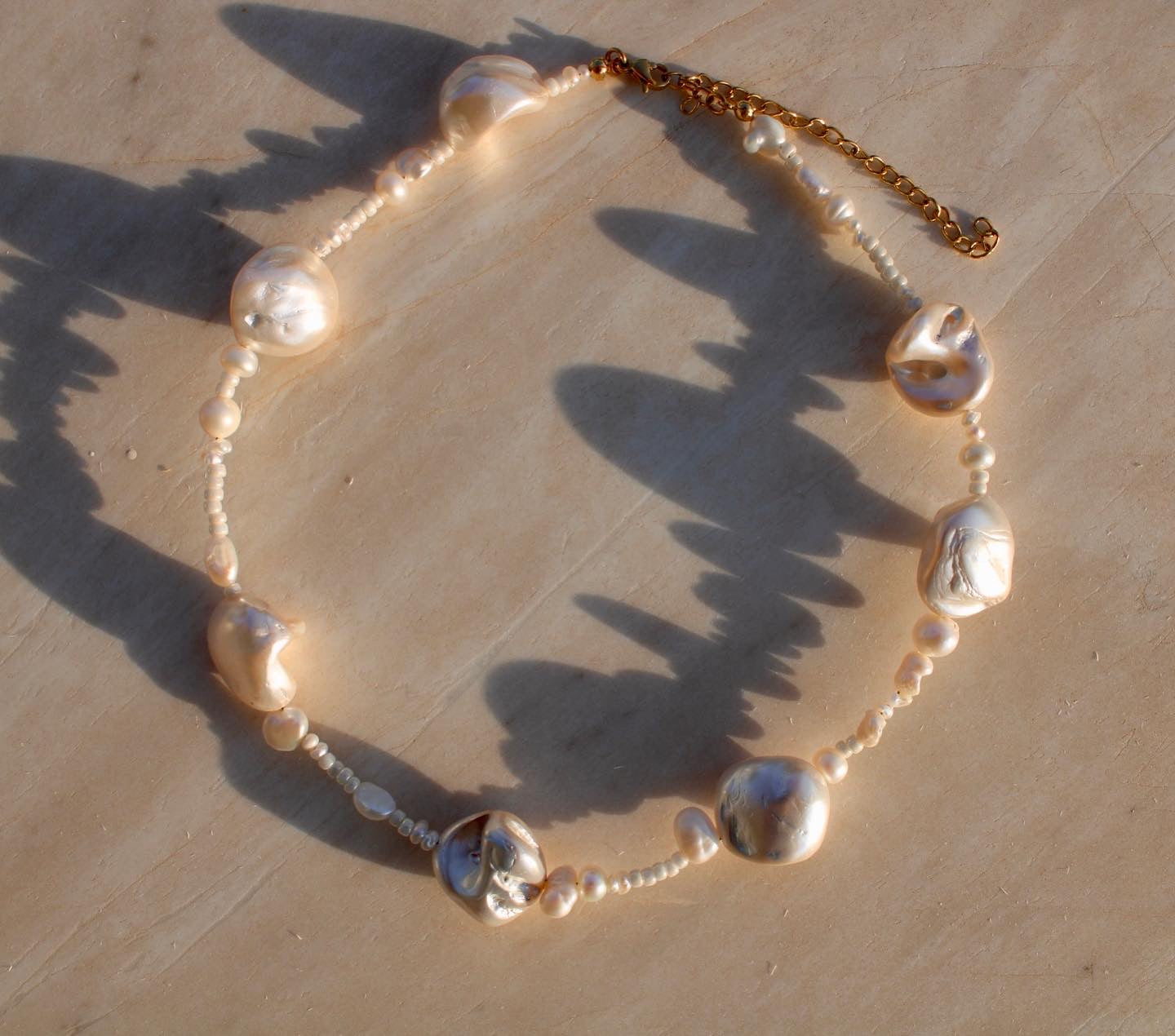 Unique mother of pearl shell necklace featuring a blend of small and large pearls, adding a distinctive touch to your look.