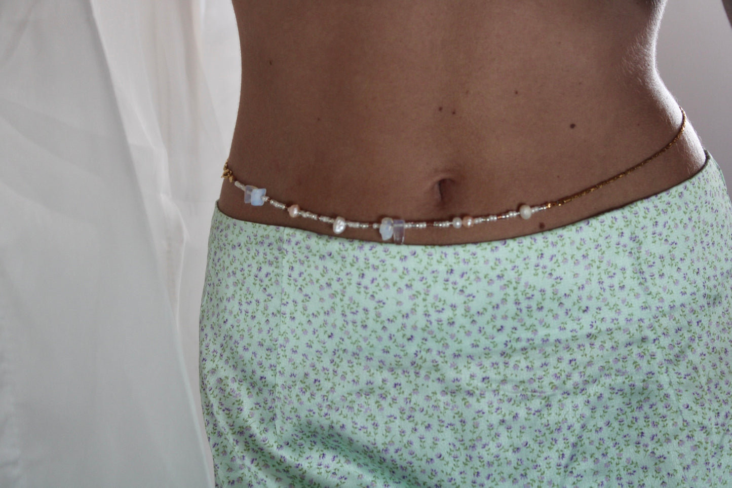 Belly chain featuring freshwater pearls and beads on a luxurious golden chain, adding a touch of elegance to your ensemble.