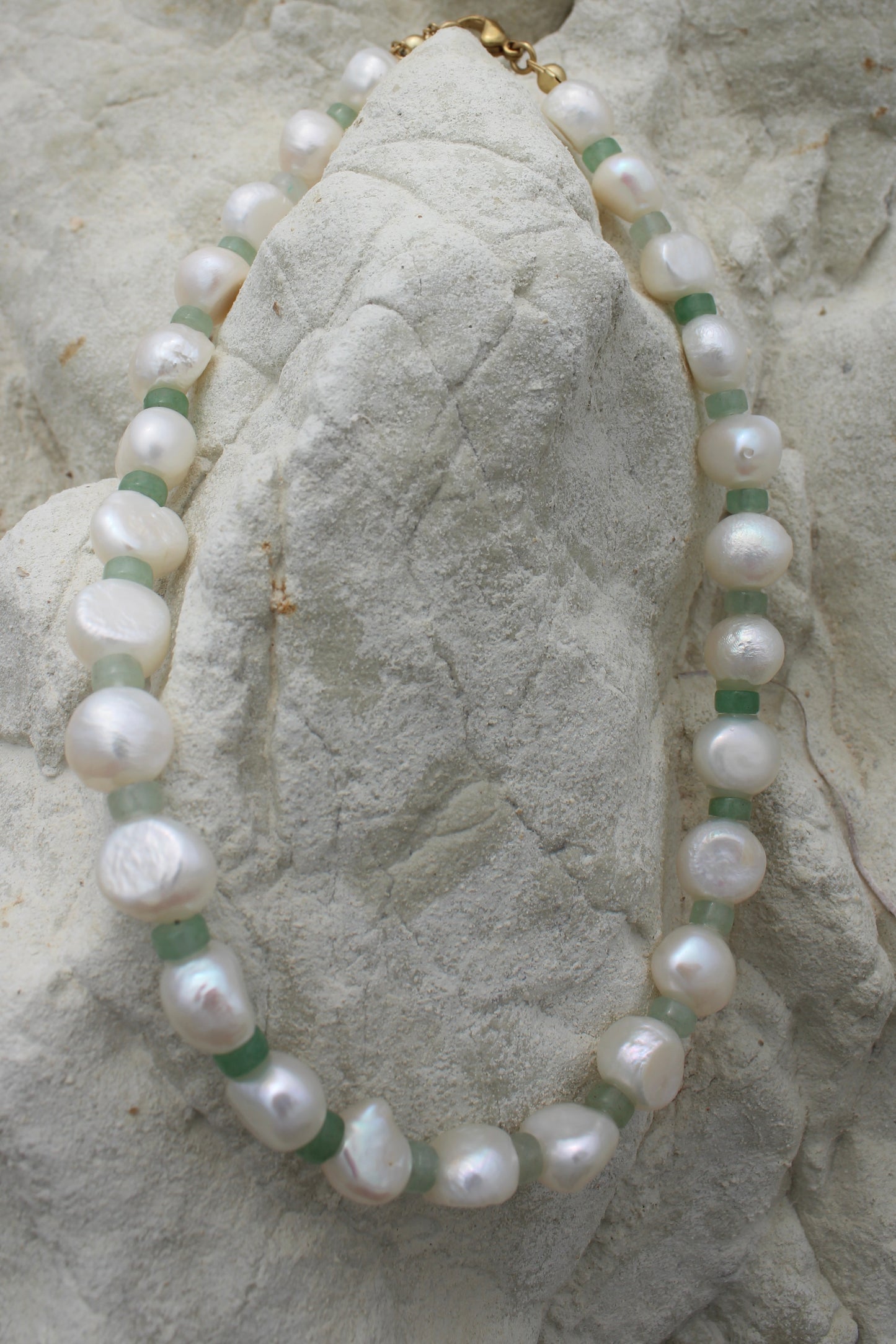 Elegant white freshwater pearl necklace featuring a motif design adorned with small green beads, adding a touch of sophistication to any ensemble.