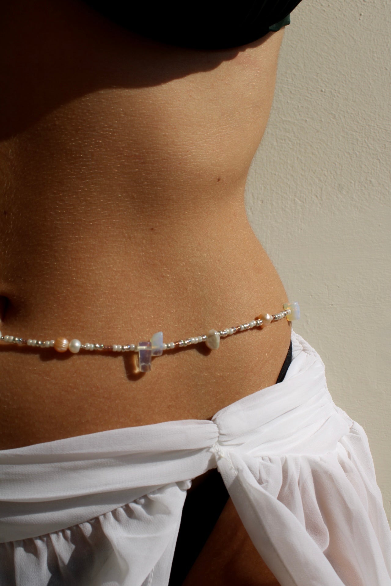 Belly chain featuring freshwater pearls and beads on a luxurious golden chain, adding a touch of elegance to your ensemble.