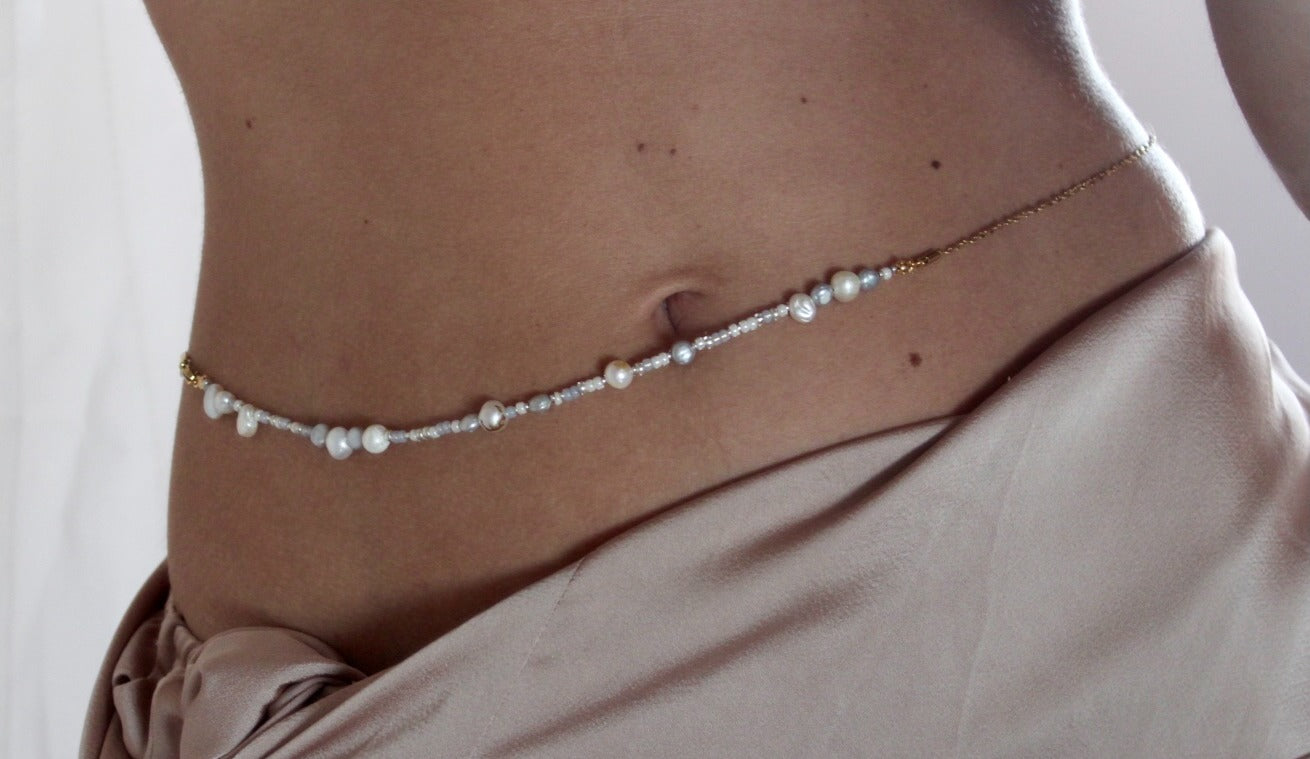 Belly chain featuring freshwater pearls and beads on a luxurious golden chain, adding a touch of elegance to your ensemble.