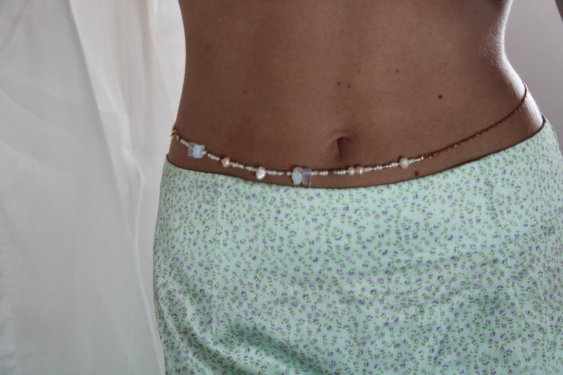 Belly chain featuring freshwater pearls and beads on a luxurious golden chain, adding a touch of elegance to your ensemble.