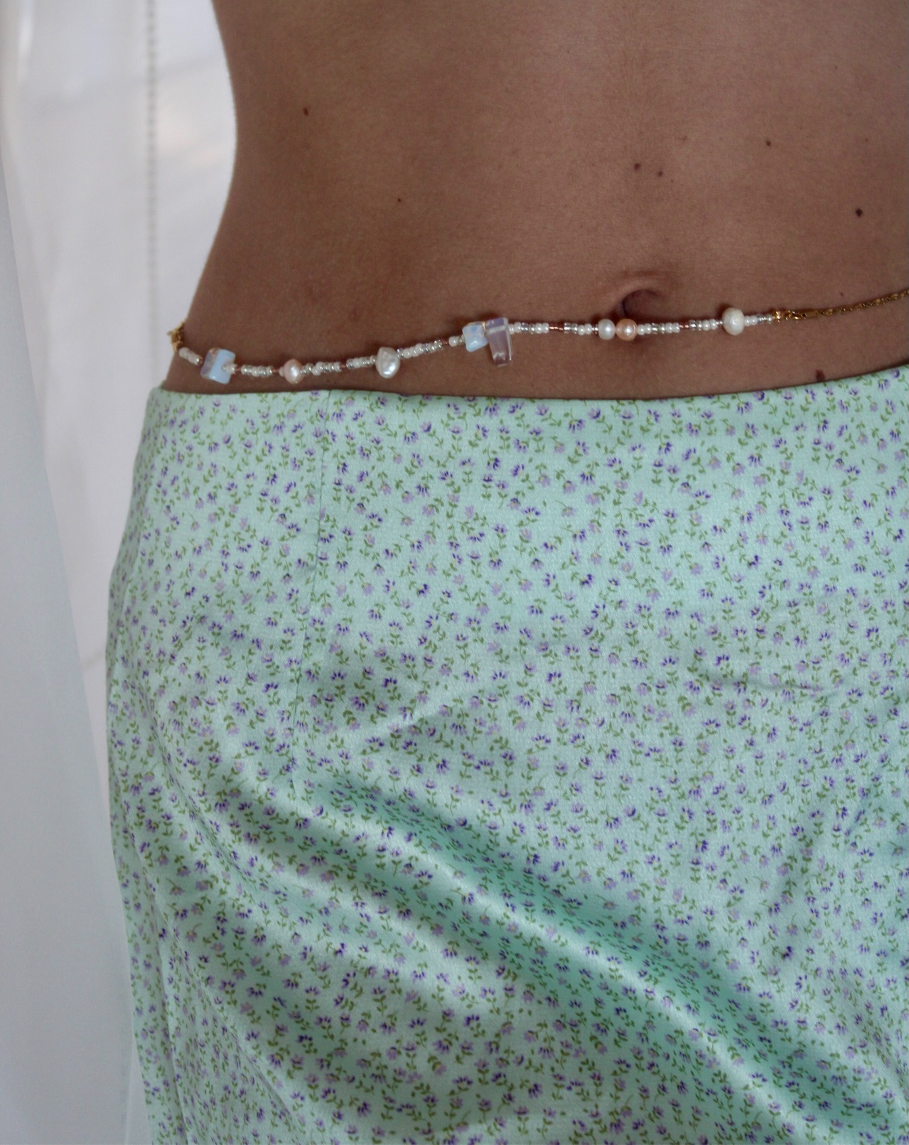 Belly chain featuring freshwater pearls and beads on a luxurious golden chain, adding a touch of elegance to your ensemble.